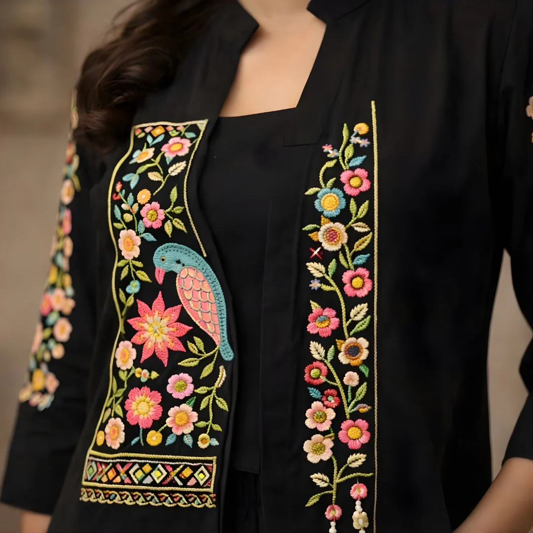 Bird and floral embroidery detail on black co-ord jacket front panel